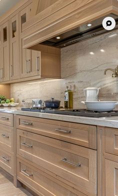 a large kitchen with wooden cabinets and white counter tops is shown in this image, there are two bowls on the stove top