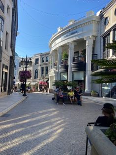 people sitting on benches in front of buildings