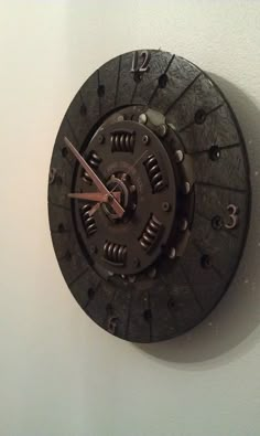 a clock that is on the wall with gears attached to it's face and hands