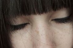 a close up of a woman's face with freckles on her eyes