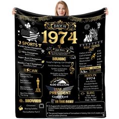 a woman holding up a black and gold poster with the history of sports in america