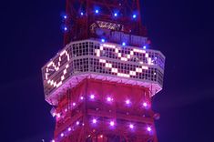 the tower is lit up with purple lights