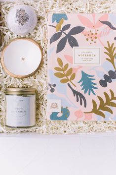 an open notebook, candle and other items in a gift box