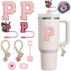 a white coffee cup with pink letters and keychains attached to the handle, along with other accessories