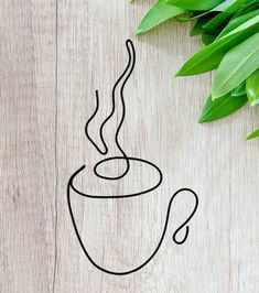 a drawing of a coffee cup on top of a wooden table next to green leaves