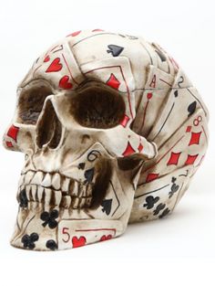 a skull with playing cards on it's face is shown in front of a white background