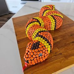 three orange and yellow balls sitting on top of a wooden table next to an oven