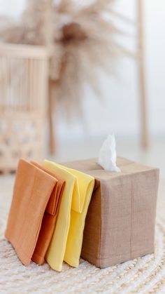 three folded napkins sitting on top of each other in front of a wicker basket