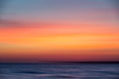 an orange and blue sunset over the ocean