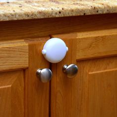 a close up of a door handle on a wooden cabinet