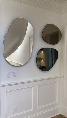 three circular mirrors mounted to the wall