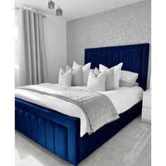 a bed with blue headboard and pillows in a bedroom