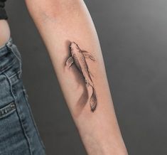 a woman's arm with a fish tattoo on it