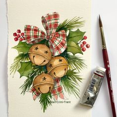 a watercolor painting of bells and holly on a white paper with a red brush next to it