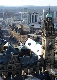 an aerial view of a city with tall buildings and clock tower in the foreground