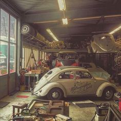 an old vw bug is parked in a garage