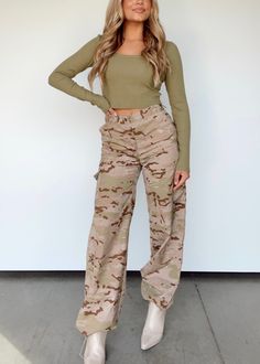 Take your everyday look to the next level with our Disguise Yourself Cargo Pants. Made with a textured, soft material, these neutral pants feature a mid rise, wide leg, camo print, button and zipper closure, and cargo pocket details for a timeless, elevated look. With a drawstring jogger capability, these timeless, trendy pants are a must-have versatile statement piece. Function meets fashion in these luxurious cargo pants. 100% Polyester Hand wash cold. Light Camo Pants, Neutral Pants, Trendy Pants, Drawstring Jogger, Camo Pants, Cargo Pocket, Camo Print, Rib Cage, Pocket Detail