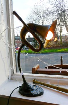 a desk lamp sitting on top of a window sill