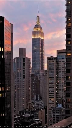 the empire building is lit up at night in new york city, ny on a cloudy day