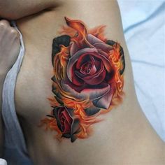 a woman's stomach with a rose tattoo on the side and flames coming out of it