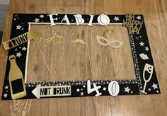 a wooden table topped with cake toppers and paper cutout signs that say fabo, not drink