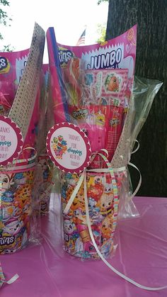 two baskets filled with candy sitting on top of a pink table