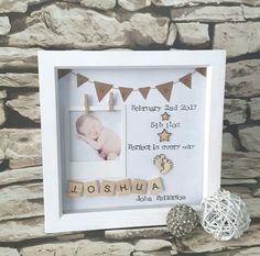 a baby's first year photo frame is displayed next to a stone wall