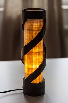 a lamp that is sitting on top of a table with a black ribbon around it