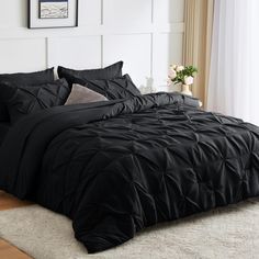 a black comforter set on a bed in a room with white walls and windows