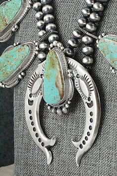 This stunningly beautiful turquoise and sterling silver squash blossom necklace and earrings set was made by Navajo silversmith Tom Lewis. The backs of the Naja and earrings are signed Tom Lewis and stamped Sterling.Necklace: 24"Naja:Length: 3 1/8"Width: 2 5/8"Blossom:Length: 1 3/4"Width: 1 1/8"Earrings:Length: 2 1/2"Width: 1 1/8"Free shipping on all orders! We ship with USPS and always include tracking. All orders ship within a day of payment.Returns are accepted up to 30 days after you receive your order. Just send us a message. Our shop offers cash back or store credit. The item must be returned in new condition. Turquoise Jewelry Squash, Turquoise Jewelry Squash Blossom, Red Squash Blossom Necklace, Native American Jewelry Turquoise Squash Blossom Necklace, Squash Blossom Necklace Sterling Silver Mounted, Tom Lewis, Silver Squash Blossom Necklace, Sterling Necklace, Squash Blossom Necklace