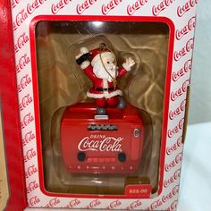 a coca - cola christmas ornament with a santa clause on it's chest