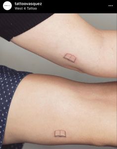 two people with tattoos on their arms and legs, one has a book in the middle