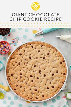 a giant chocolate chip cookie in a pie pan with sprinkles on the table