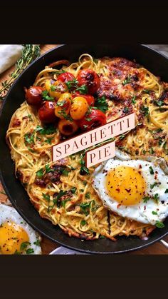 spaghetti with fried eggs and tomatoes in a skillet