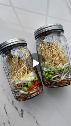 two mason jars filled with noodles and vegetables