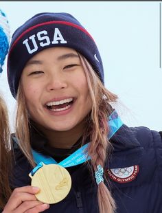 two young women standing next to each other holding up their gold and silver medals