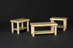 three small wooden tables sitting on top of a black floor