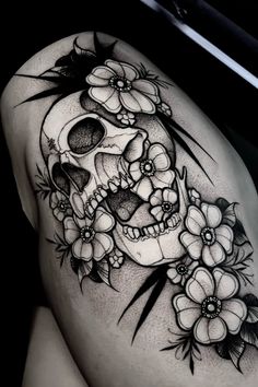 a woman's thigh with a skull and flowers on it