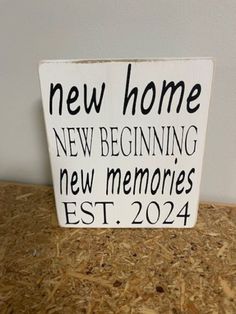 a wooden sign that says new home, new beginning and new memories est 2024