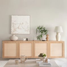 a living room with a coffee table and two vases on top of the tables