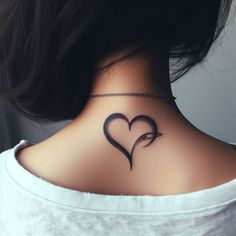 a woman's back neck with a heart tattoo on the left side of her neck