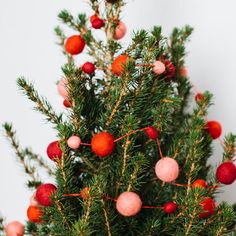 a small christmas tree with red balls on it