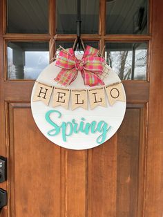 a hello spring door hanger hanging on a front door