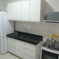 a kitchen with white cabinets and black counter tops