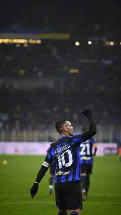 a soccer player is holding his hand up in the air while standing on a field