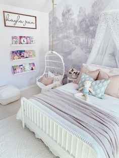 a bedroom with a bed, chair and pictures on the wall above it is decorated in pastel tones