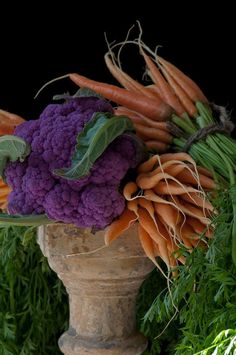 carrots, cauliflower and broccoli are arranged in an urn