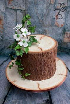 a cake decorated with flowers on top of a wooden plate