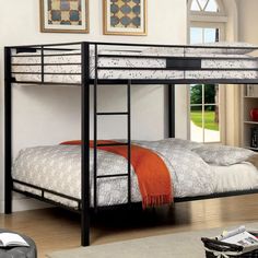 a black metal bunk bed sitting in a living room next to a book shelf and window