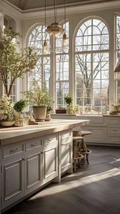 a kitchen filled with lots of windows and white cabinets